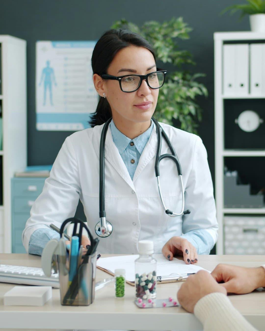Médecin dans son cabinet, en consultation avec un patient devant son poste de travail
